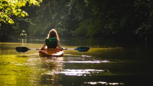 Woman kayaking down the river.