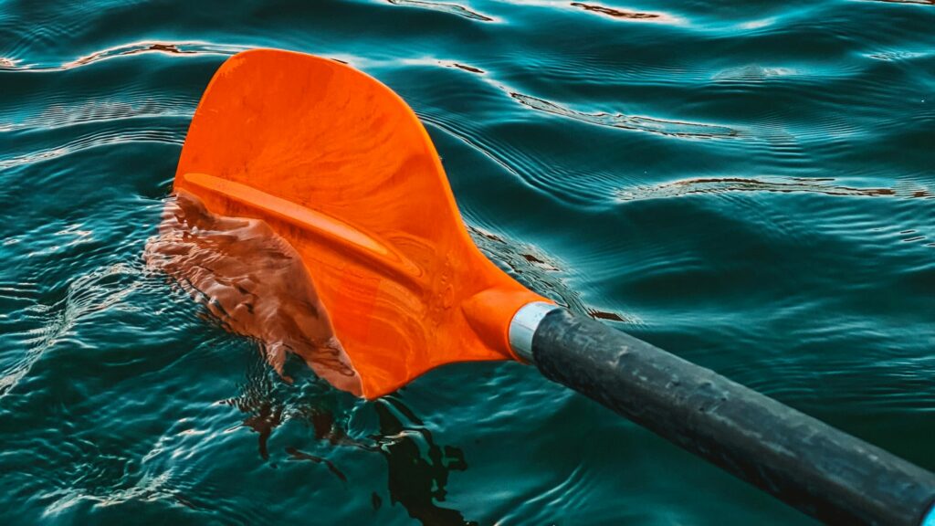 Orange paddle in the clear turquoise water.